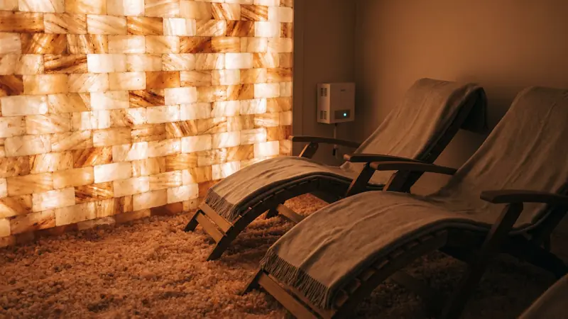 Salt room with backlit Himalayan salt wall and loungers in a Dubai private wellness suite